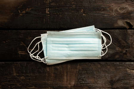 a stack of medical masks, lies on a wooden table, a medical maskの写真素材
