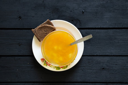vegetable pea soup and a slice of black bread on a black wooden table in the kitchen, soup without meatの写真素材