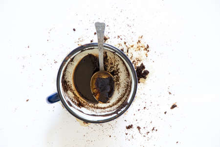 a cup with overturned coffee on a white background and a teaspoon lies next to it, spilled coffee on a white backgroundの写真素材