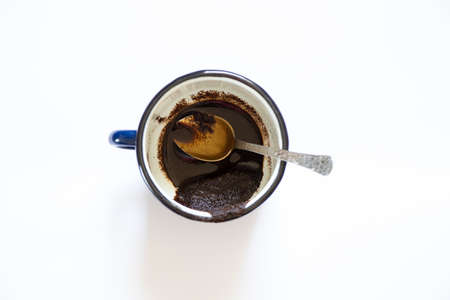 a cup with overturned coffee on a white background and a teaspoon lies next to it, spilled coffee on a white backgroundの写真素材