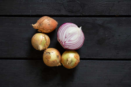 onions are on a black wooden board, onions are on the tableの写真素材