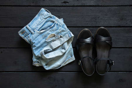 womens shorts and summer sandals on a black wooden background, fashion, womens clothing and shoesの写真素材