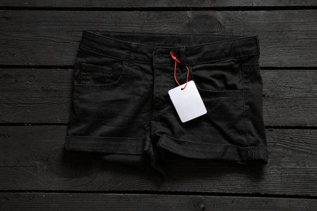 womens denim shorts with white blank paper price tag for text on table, price tag on shorts, place for priceの写真素材