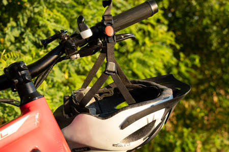 bicycle helmet on the handlebars of an e-bike at sunset in nature, cycling helmet on a bicycleの写真素材