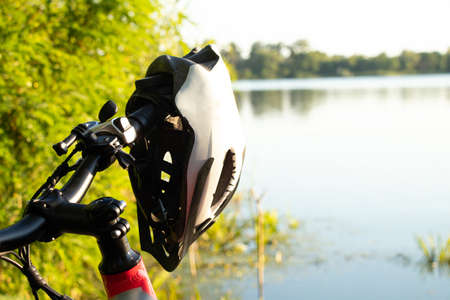 bicycle helmet on the handlebars of an e-bike at sunset in nature, cycling helmet on a bicycleの写真素材