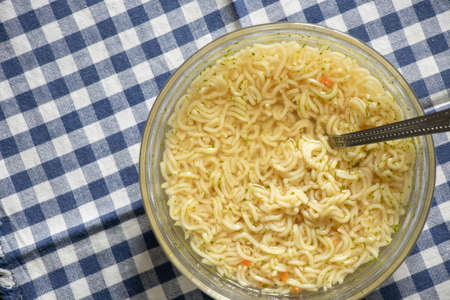boiled pasta with yushka in a plate on a black wooden table for lunch, noodles in a plate on the tableの写真素材