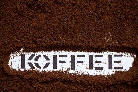 ground roasted coffee on white background and next to text coffee, coffee background, text coffee