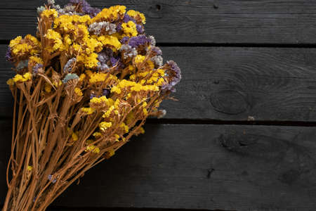 flowers limonium sinuatum on a wooden background, floral background, dried flowersの写真素材
