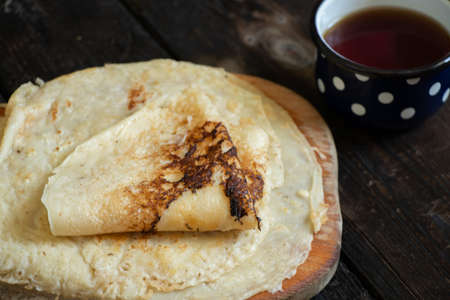 a stack of pancakes next to a cup of coffee on a wooden old table, pancakes for breakfastの写真素材