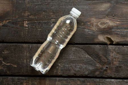 plastic bottle with water lies on an old wooden table, bottle with water, water
