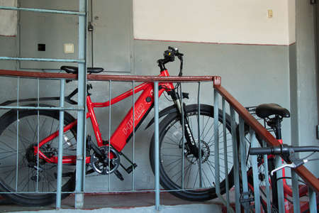 Ukraine Dnipro 07/23/2021 - Two red bicycles stand on the stairs to the entrance of a residential building on the floor they brought apartments, a bicycle in the houseのeditorial素材