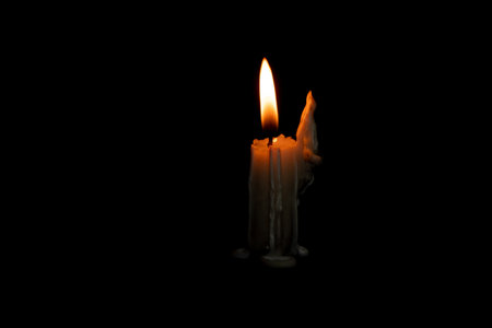 flame of a burning candle in the dark, candle fire on a black backgroundの写真素材
