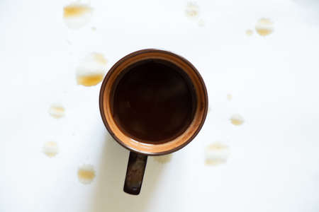 a cup of coffee on a white background and drops of spilled coffee on a white background, a cup of coffeeの写真素材