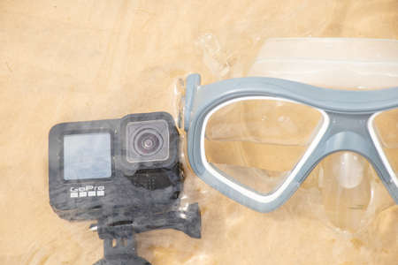 Ukraine Dnipro 08/05/2021 - Camera and mask GoPro HERO 9 for diving on the beach in the water by the lake, action camera on the lakeのeditorial素材