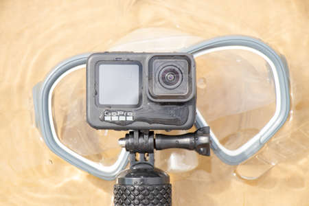 Ukraine Dnipro 08/05/2021 - Camera and mask GoPro HERO 9 for diving on the beach in the water by the lake, action camera on the lakeのeditorial素材