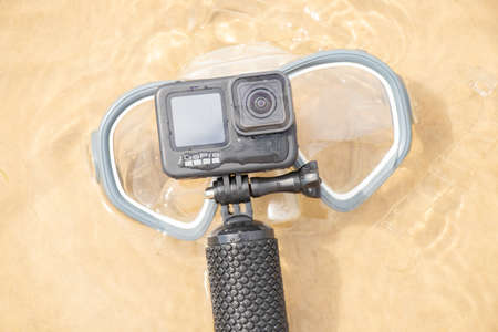 Ukraine Dnipro 08/05/2021 - Camera and mask GoPro HERO 9 for diving on the beach in the water by the lake, action camera on the lakeのeditorial素材