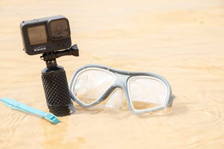 Ukraine Dnipro 08/05/2021 - Camera and mask GoPro HERO 9 for diving on the beach in the water by the lake, action camera on the lakeのeditorial素材
