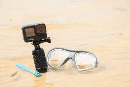 Ukraine Dnipro 08/05/2021 - Camera and mask GoPro HERO 9 for diving on the beach in the water by the lake, action camera on the lakeのeditorial素材