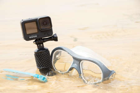 Ukraine Dnipro 08/05/2021 - Camera and mask GoPro HERO 9 for diving on the beach in the water by the lake, action camera on the lakeのeditorial素材
