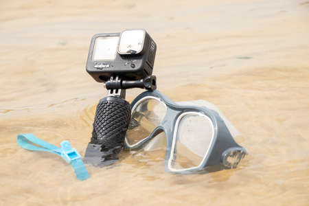 Ukraine Dnipro 08/05/2021 - Camera and mask GoPro HERO 9 for diving on the beach in the water by the lake, action camera on the lakeのeditorial素材