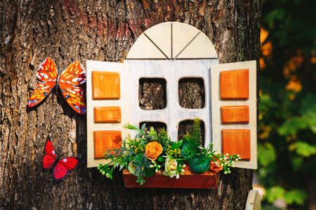 fabulous little children's wooden house in a tree trunk in a park in the summer in the sun in Ukraine, a house for a gnome, a house from a fairy taleの写真素材