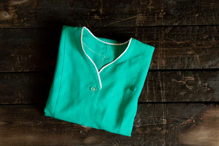 an old doctor's medical suit lies on a wooden table, a medical uniform in a crust, work clothesの写真素材