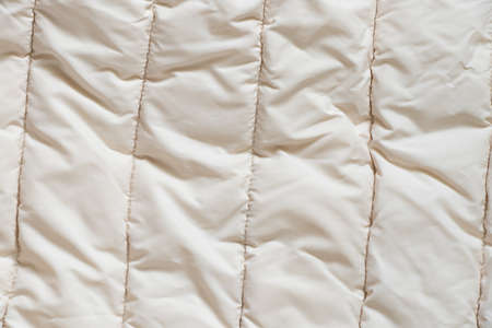 women's padded white soft jacket as background, background of soft light fabricの写真素材