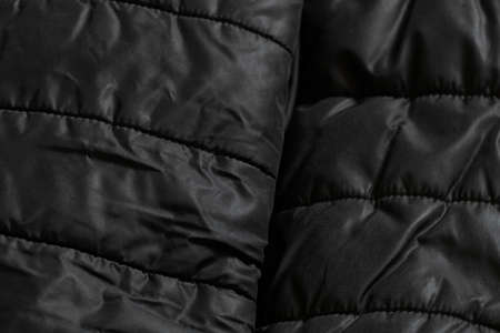 women's padded black padded jacket as background, background of soft black fabricの写真素材