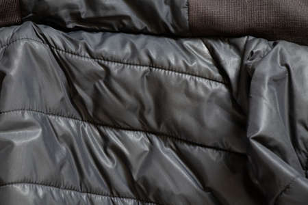 women's padded black padded jacket as background, background of soft black fabricの写真素材
