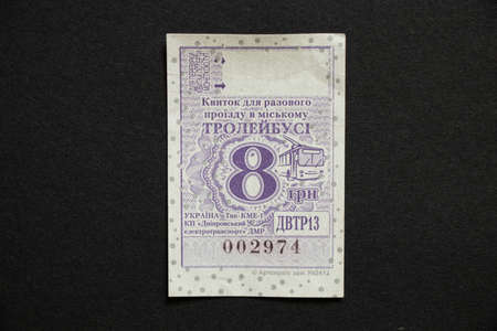 Ukraine Dnipro 12.08.2021 - paper trolleybus ticket for 8 hryvnia one-time travel, the ticket lies on a black backgroundのeditorial素材