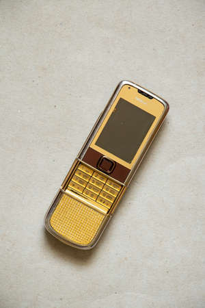 Ukraine Dnepr 19.08.2021 - Nokia 8800 gold lies on gray light paper, old phone, mobile phoneのeditorial素材