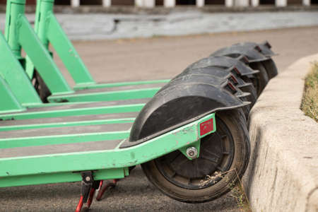 Ukraine Dnipro 31.08.2021 - rent of green electric scooters in the city park, city transport for...