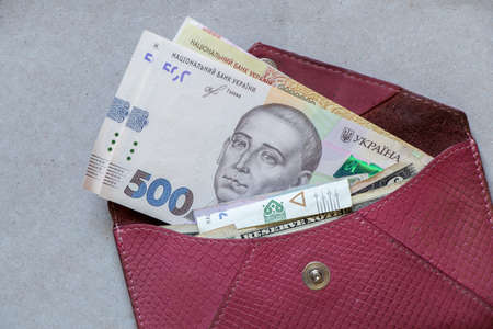 five hundred hryvnia bill lies in a red leather wallet on the table, Ukrainian hryvnia