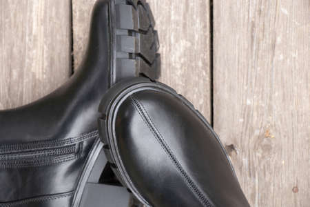 black high womens boots with thick soles stand on the old plank in the street, womens winter shoes, shoesの写真素材