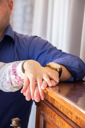 hands of a husband and wife lie on the piano together, hands of a woman and a man together, family relationshipsの写真素材