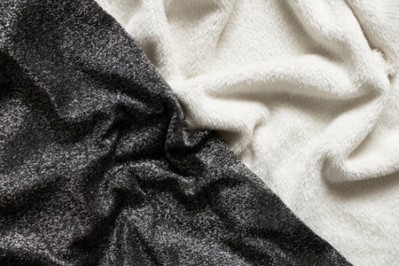 black fabric with sequins and white soft warm fabric wrinkled as background, two types of fabric as background black and white, fashionの写真素材