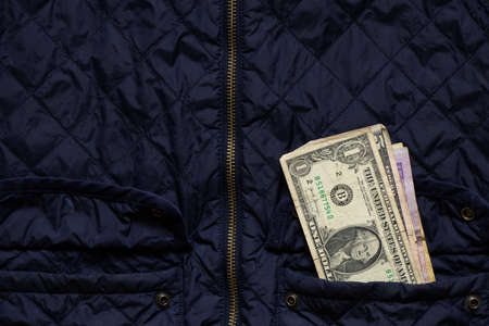 american dollar in winter jacket pocket, money in pocket, financial theme