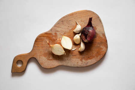 onions and garlic lie on a wooden board on a white background, vegetablesの写真素材
