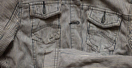 women's denim striped jacket lies on a wooden table, denim jacket striped black and white, fashionable clothesの写真素材