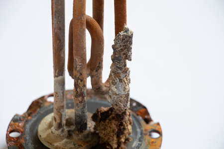 heating ten from a water heater after 8 years of operation broken on a white background, replacing an old ten from a boiler, repairing a broken partの写真素材