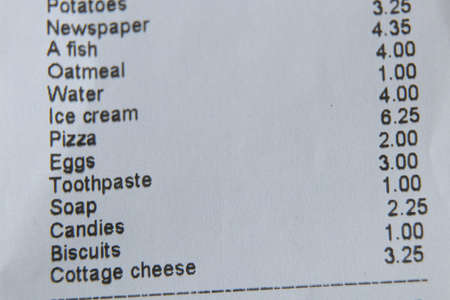 a check from the supermarket is on the table, a paper check with purchases, finances totals