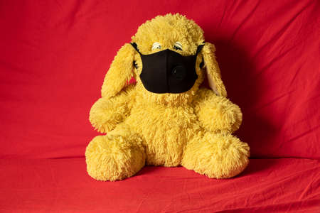 children's soft plush toys in medical mask lie on the red sofa, healthcare and medicine, children's...