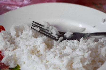 rice porridge in plates with a fork in the kitchen at home, rice in a plate, vegan foodの写真素材