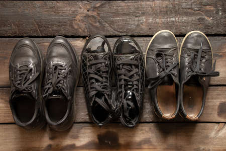 a lot of women's shoes sneakers and old sneakers on a wooden floor, women's shoes, black sneakersの写真素材
