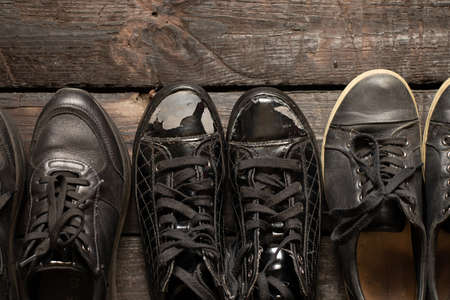 a lot of women's shoes sneakers and old sneakers on a wooden floor, women's shoes, black sneakersの写真素材
