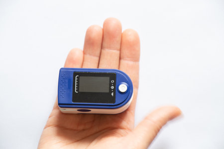 pulse oximeter on the finger of a woman on an isolated background, measure the level of oxygen in...