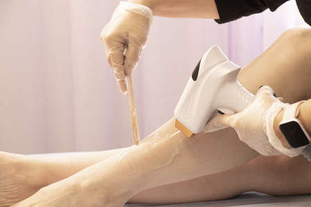 removal of hair with a laser device from a girl's leg in a beauty salon, Aparati for laser treatment hair removal from a girl's bodyの写真素材