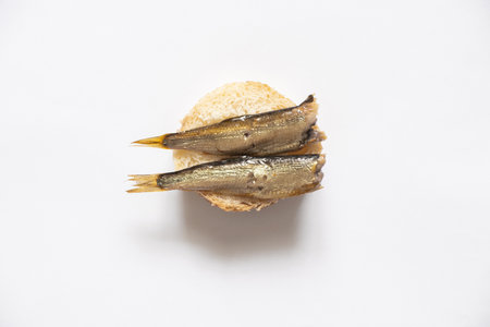sprats on a piece of white bread, sandwich with fish on an isolated backgroundの写真素材