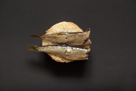 sprats on a piece of white bread, sandwich with fish on an isolated backgroundの写真素材