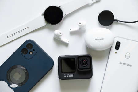 Ukraine Dnipro 11/30/2021 - Smart watch Samsung Galaxy Watch and Headphones Huawei Freebuds 4i and Apple iPhone 11 and GoPro Hero 9, technologiesのeditorial素材